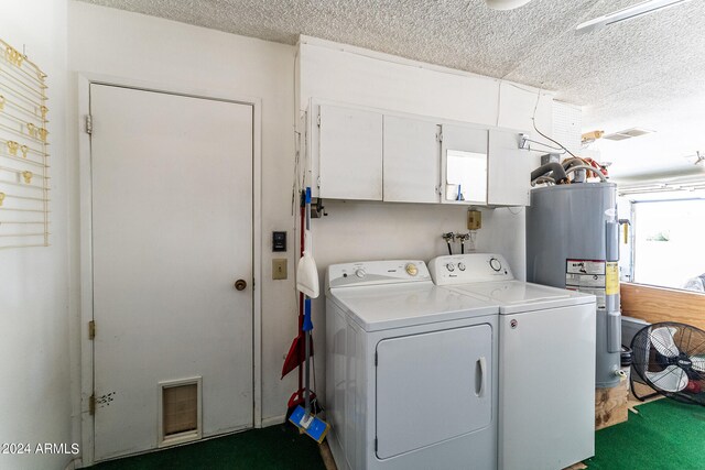 laundry room featuring electric water heater, cabinets, independent washer and dryer, and a textured ceiling