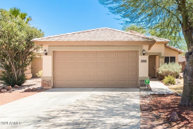 view of front facade featuring a garage, driveway, a tile roof, and stucco siding