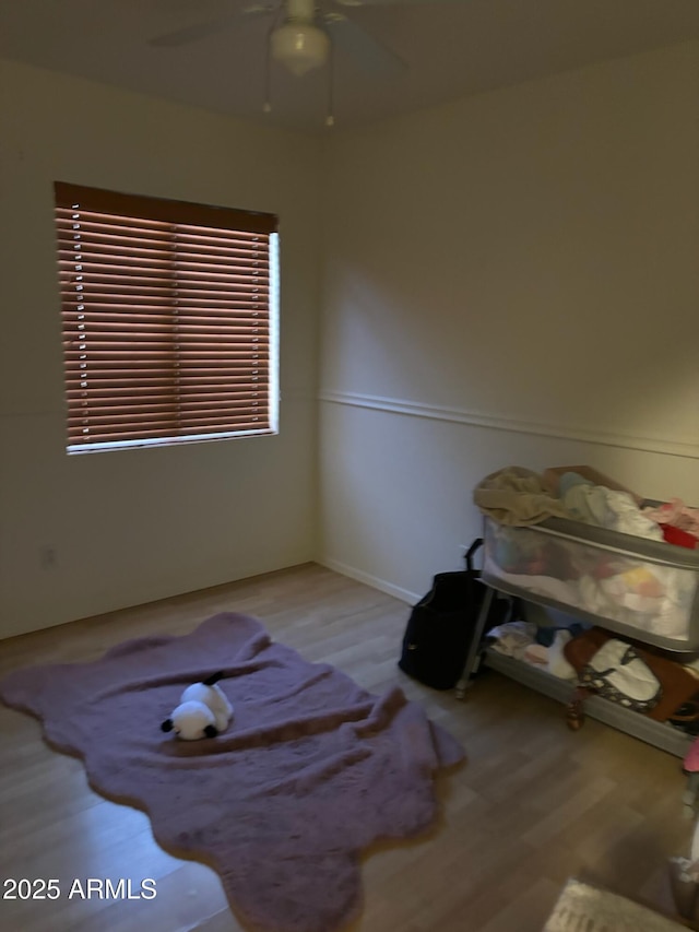 interior space with wood finished floors and a ceiling fan