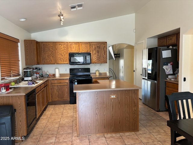 kitchen with arched walkways, lofted ceiling, a sink, visible vents, and black appliances