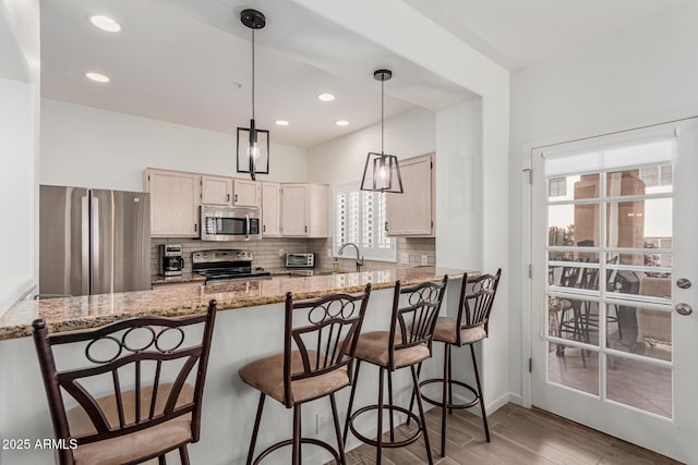 9253 N Firebrick Dr Unit 117, Fountain Hills, AZ 85268 - kitchen featuring a peninsula, backsplash, light wood-style flooring, and stainless steel appliances