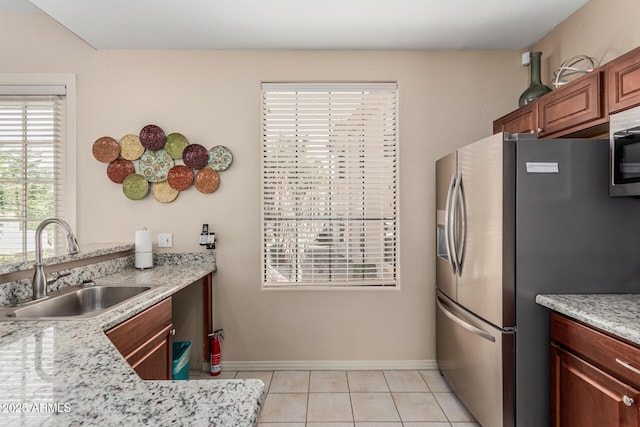 9253 N Firebrick Dr Unit 117, Fountain Hills, AZ 85268 - kitchen featuring a sink, light tile patterned floors, stainless steel appliances, baseboards, and light stone countertops