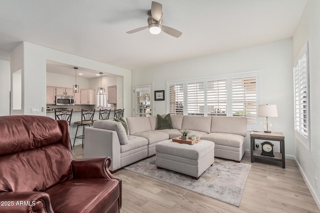 9253 N Firebrick Dr Unit 117, Fountain Hills, AZ 85268 - living area featuring baseboards, a ceiling fan, light wood-style floors, and a healthy amount of sunlight