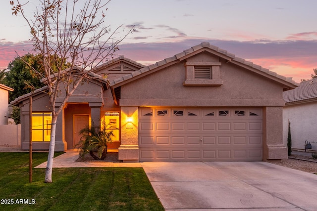 view of front of property with a garage and a lawn