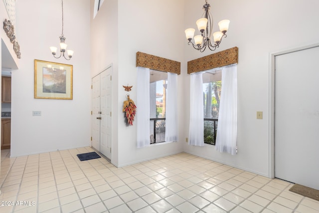 tiled foyer with a high ceiling and an inviting chandelier