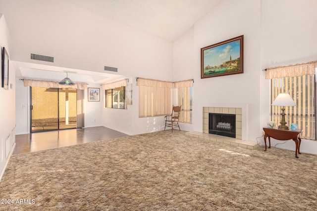 unfurnished living room featuring a fireplace, carpet floors, and high vaulted ceiling