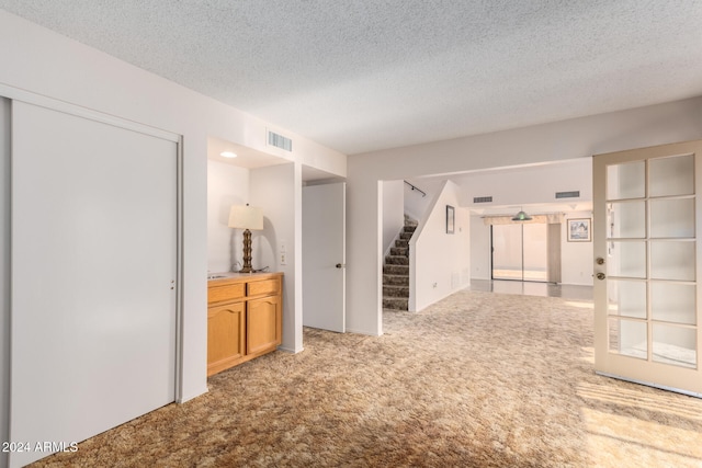 carpeted empty room with a textured ceiling