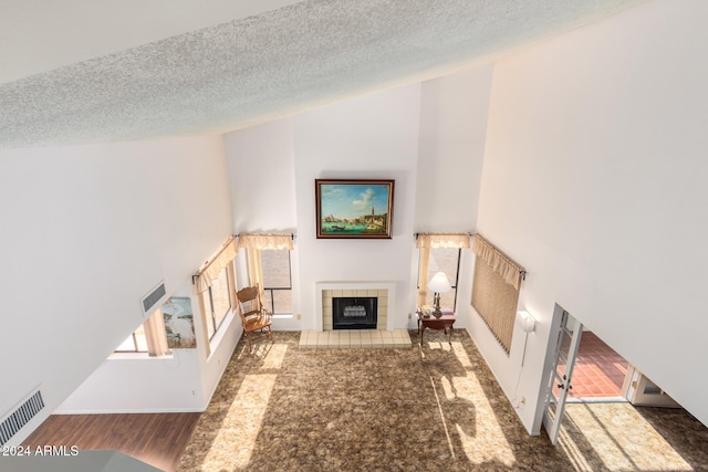 unfurnished living room featuring a fireplace, a textured ceiling, and dark hardwood / wood-style floors