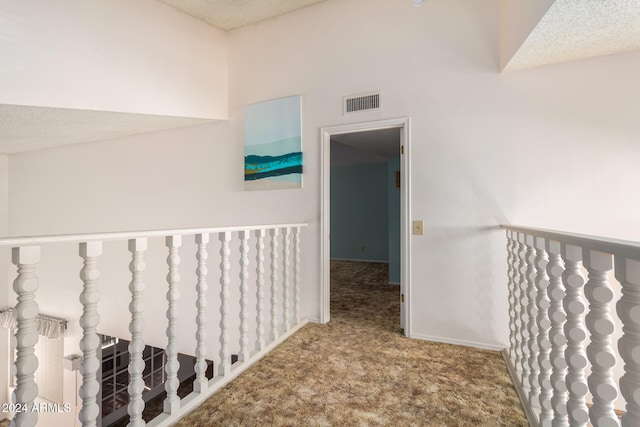 hallway featuring carpet and a textured ceiling