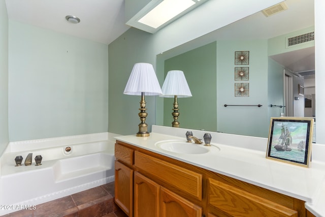 bathroom featuring tile patterned flooring, vanity, and a bath