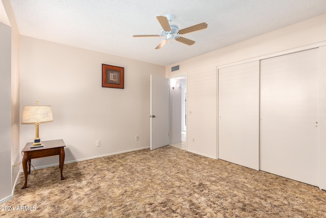 bedroom with a textured ceiling, carpet floors, a closet, and ceiling fan