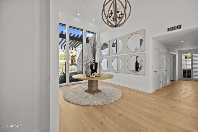 foyer featuring hardwood / wood-style floors, a wealth of natural light, and a notable chandelier