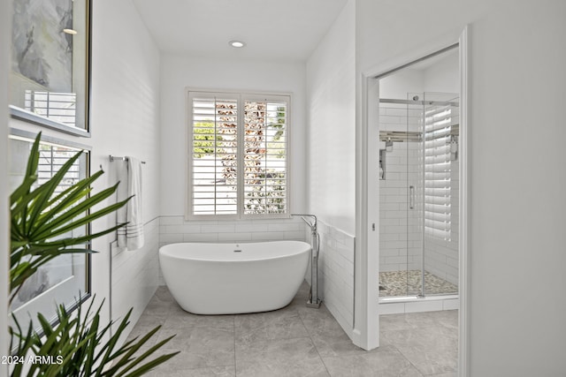 bathroom with tile walls, tile patterned flooring, and plus walk in shower