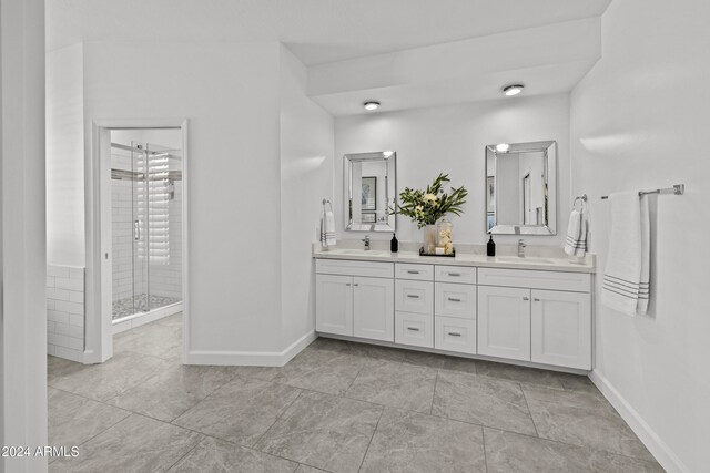 bathroom featuring a shower with door, vanity, and tile patterned floors