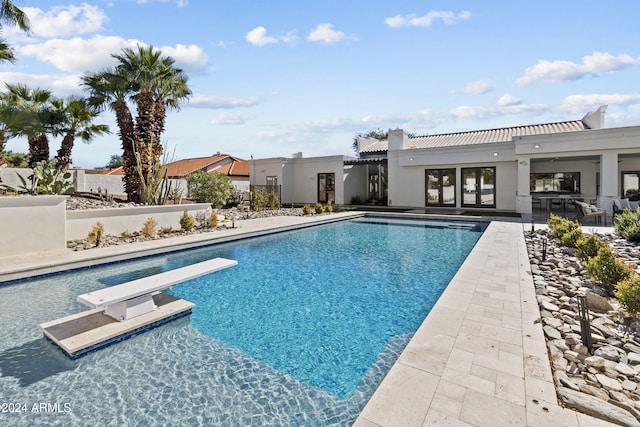 view of pool featuring a diving board and a patio