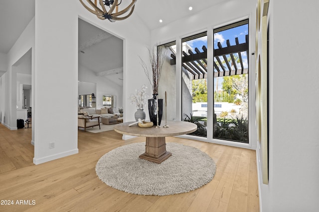 entrance foyer featuring wood-type flooring, beam ceiling, and high vaulted ceiling