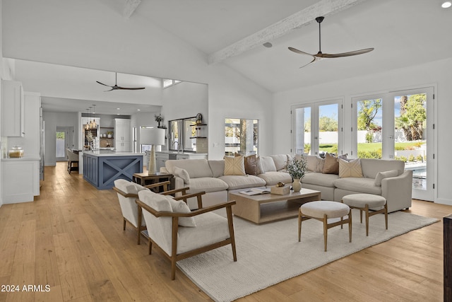 living room with beam ceiling, light hardwood / wood-style flooring, and high vaulted ceiling