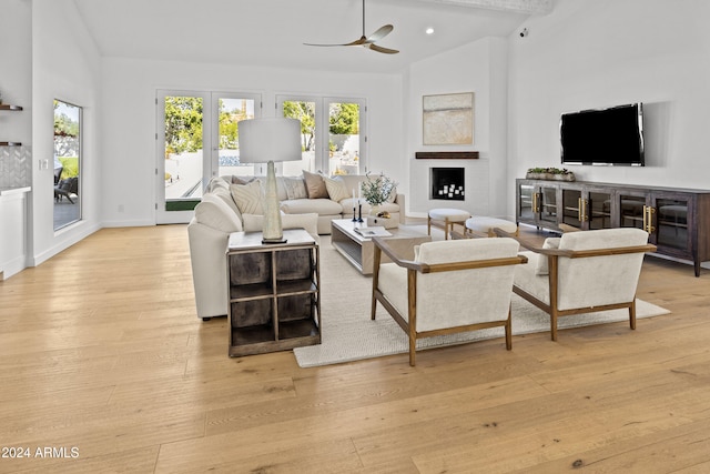 living room featuring light wood-type flooring, ceiling fan, and high vaulted ceiling