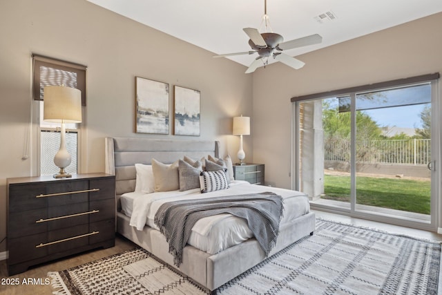 bedroom with visible vents, wood finished floors, and access to exterior