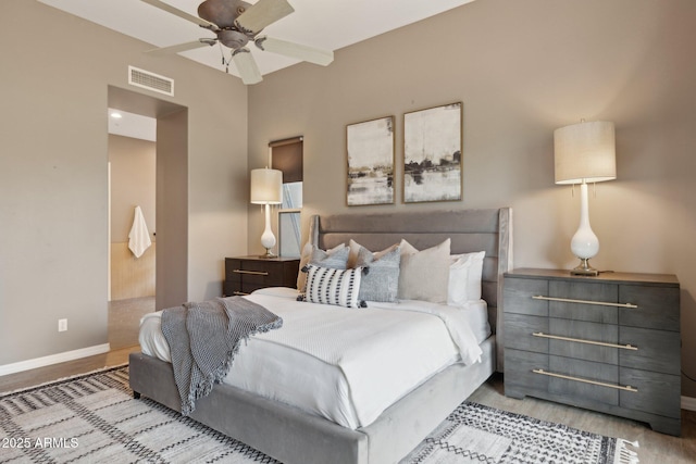 bedroom with a ceiling fan, baseboards, visible vents, and wood finished floors