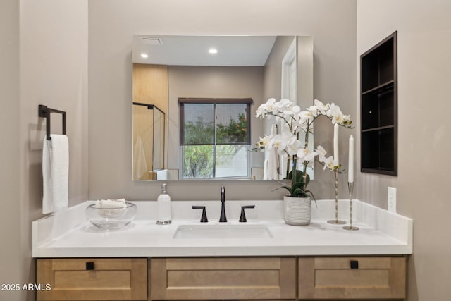 bathroom featuring vanity, visible vents, and a shower stall