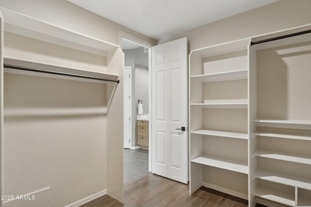 walk in closet with wood finished floors