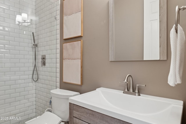 full bathroom with vanity, toilet, and tiled shower
