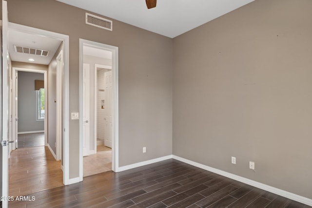 unfurnished bedroom with baseboards, visible vents, and dark wood finished floors
