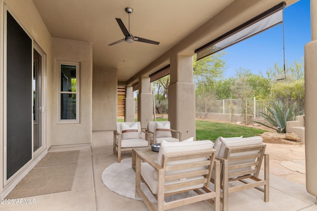 view of patio / terrace featuring fence, ceiling fan, and an outdoor living space