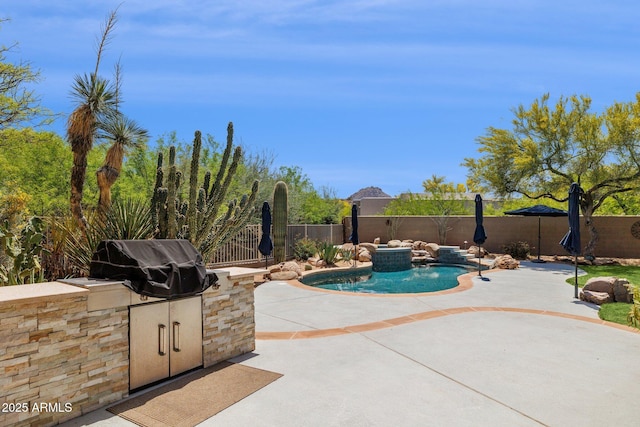 view of swimming pool with a patio, a fenced backyard, a grill, and an outdoor kitchen