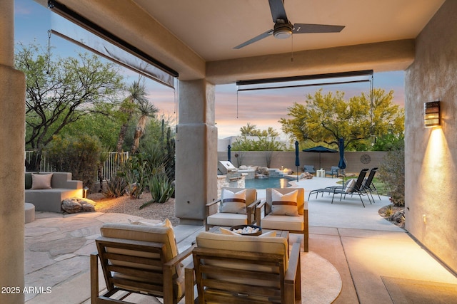 patio terrace at dusk with a fenced backyard, ceiling fan, outdoor lounge area, and area for grilling