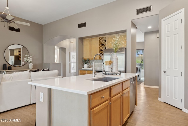 kitchen with visible vents, a sink, arched walkways, and ceiling fan