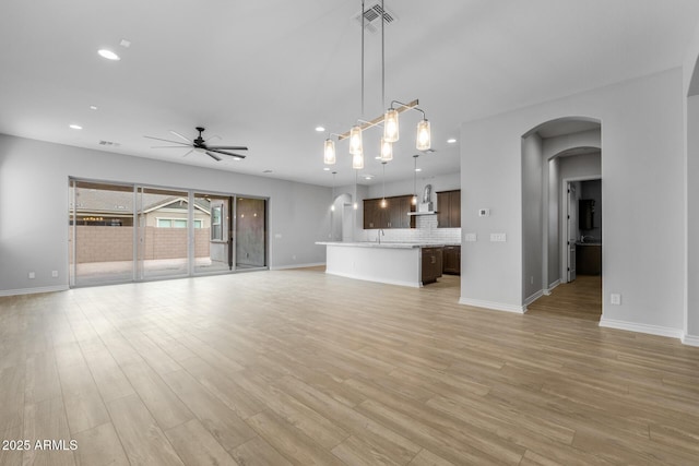 unfurnished living room with ceiling fan and light wood-type flooring