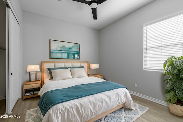 bedroom with ceiling fan, a closet, and light hardwood / wood-style floors