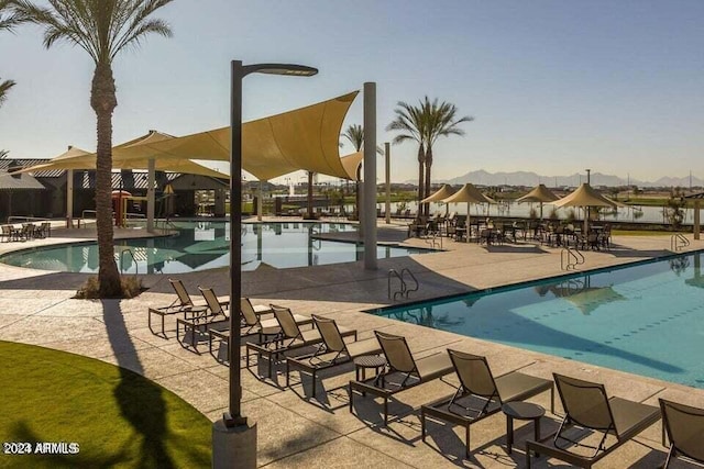 view of swimming pool featuring a water view and a patio