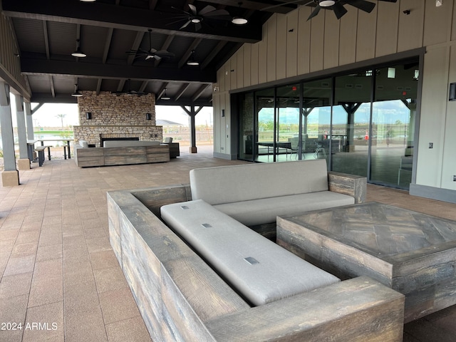 view of patio featuring ceiling fan and an outdoor living space with a fireplace