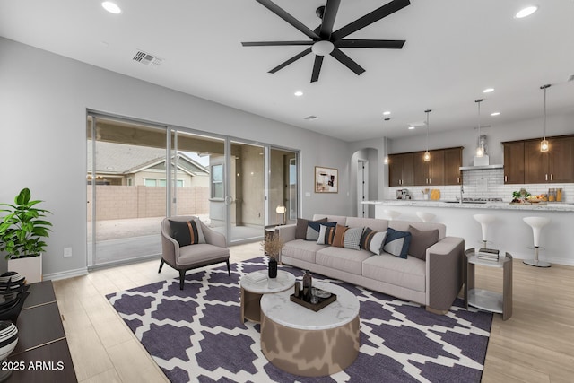 living room with ceiling fan and light wood-type flooring