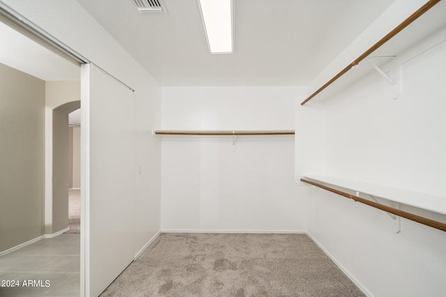 walk in closet featuring light carpet