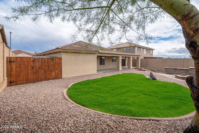 back of house with a patio and a yard