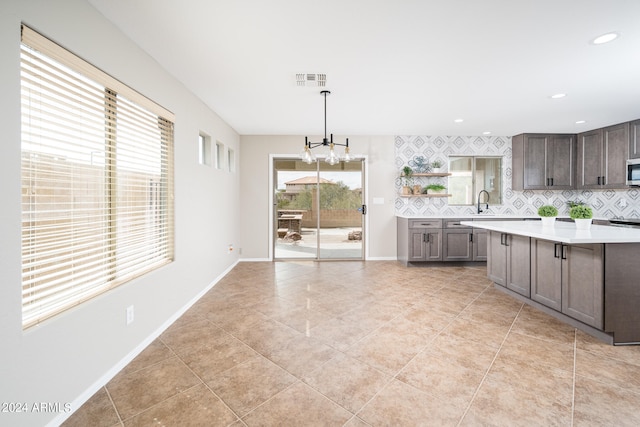 kitchen with an inviting chandelier, backsplash, and plenty of natural light