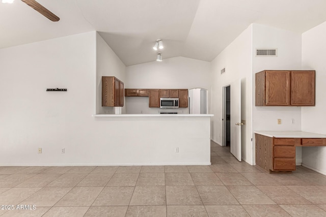 510 W Amoroso Dr, Gilbert, AZ 85233 - kitchen with stainless steel microwave, light countertops, brown cabinetry, a peninsula, and high vaulted ceiling