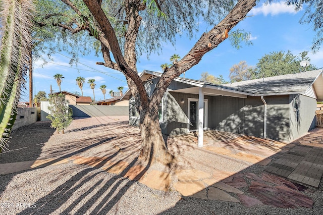 view of front of house with a patio area and fence