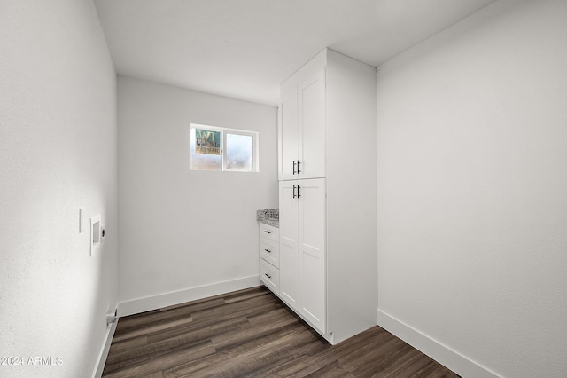 laundry area with hookup for a washing machine, dark wood-style flooring, cabinet space, and baseboards