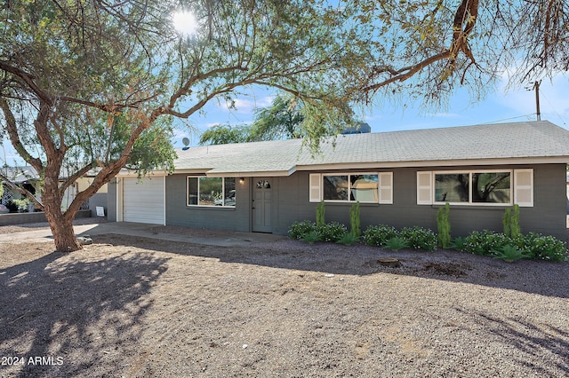 single story home with driveway, brick siding, and an attached garage