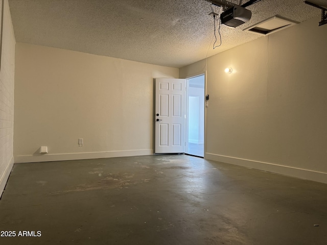 empty room with concrete flooring, a textured ceiling, and baseboards