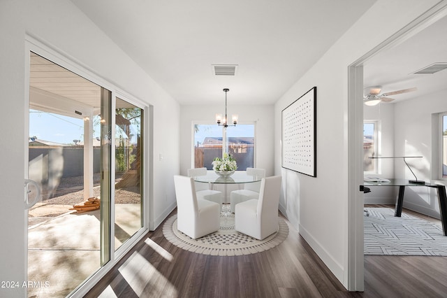 dining area with baseboards, visible vents, wood finished floors, and ceiling fan with notable chandelier