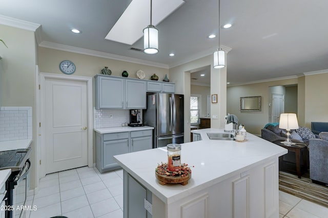 kitchen with electric range, stainless steel fridge, gray cabinets, an island with sink, and pendant lighting