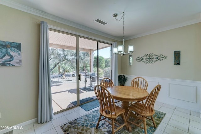 tiled dining area featuring crown molding and a notable chandelier