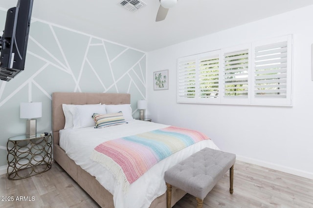 bedroom with ceiling fan, visible vents, baseboards, and wood finished floors