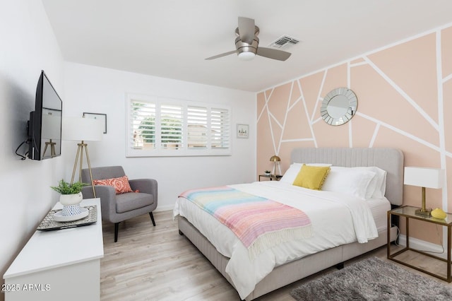 bedroom featuring light wood-style flooring, baseboards, visible vents, and ceiling fan